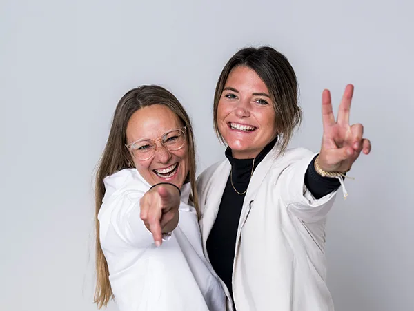 Helen und Anja lachend als zwei Mitarbeiter des Marketingteams, die sich über die super Einkaufsvorteile freuen