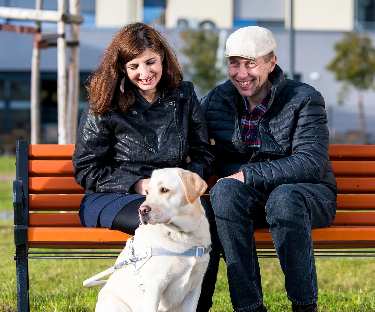 Junge Pflege mit Hund auf Sitzbank